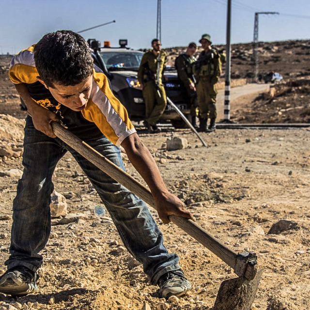 A young Palestinian boy works on the road  which connects Yatta to At-Tuwani. 